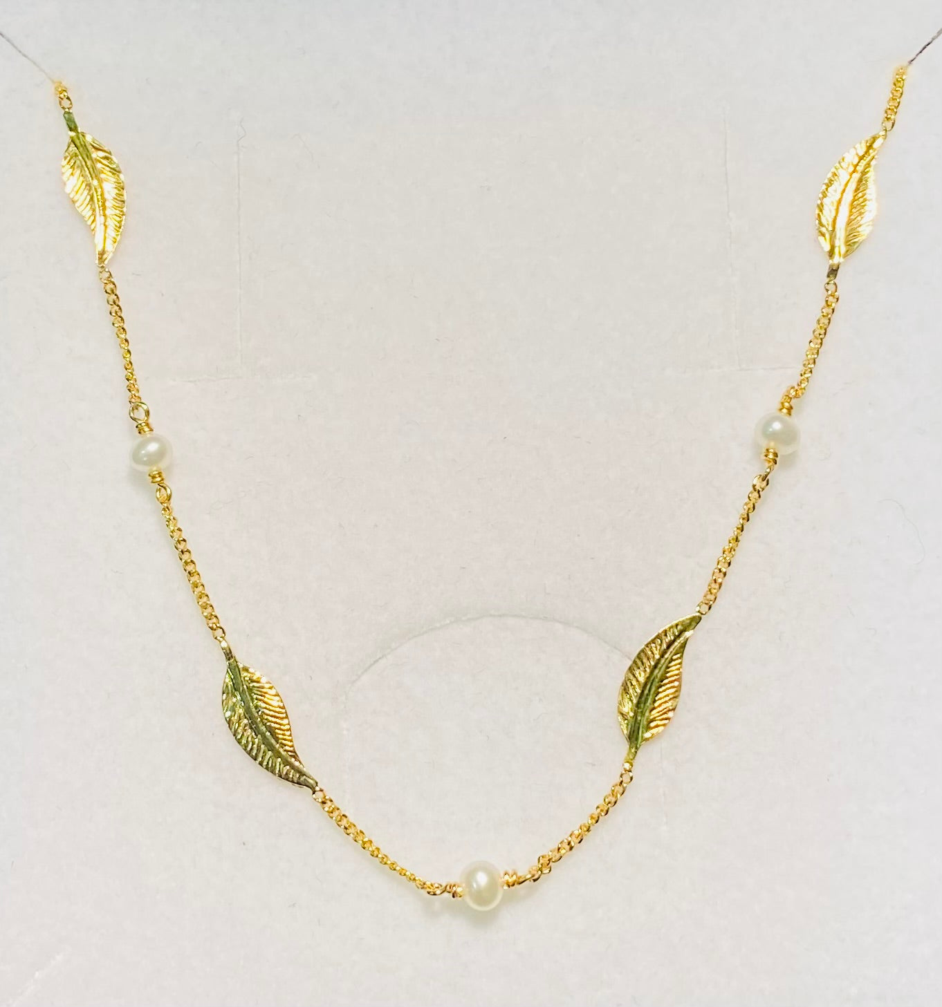 Collier en or jaune motifs plumes alternés avec des perles